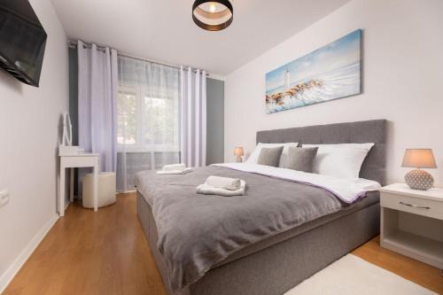 sypialnia z dużym łóżkiem i oknem w obiekcie Apartments Vugrin w mieście Šilo