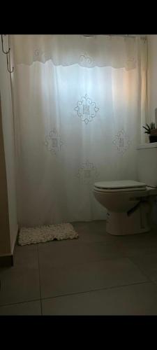 La salle de bains est pourvue de toilettes et d'un mur blanc. dans l'établissement Dpto El Bonito Posadas, à Posadas