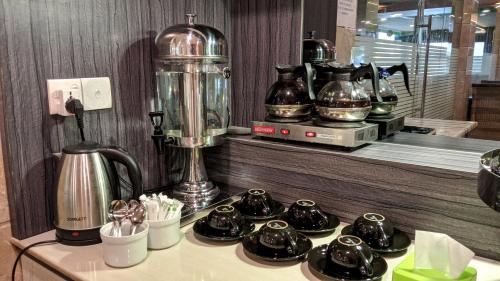 a counter with a blender and a bunch of cups at Kita Hotel in Tanjung Pinang 
