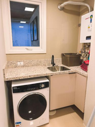 a kitchen with a sink and a dishwasher at Apto a 3 minutos da Rua Coberta de Gramado in Gramado