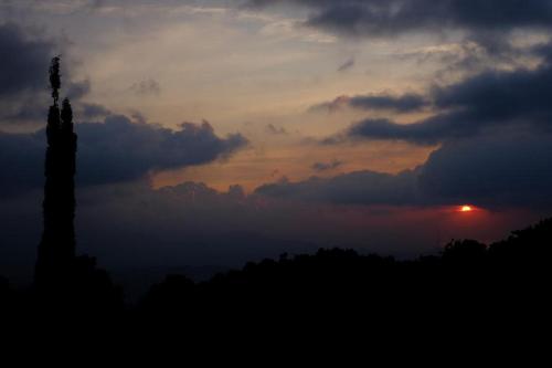 a sunset with the sun setting in the sky at KARANG SARI Guesthouse & Warung in Munduk