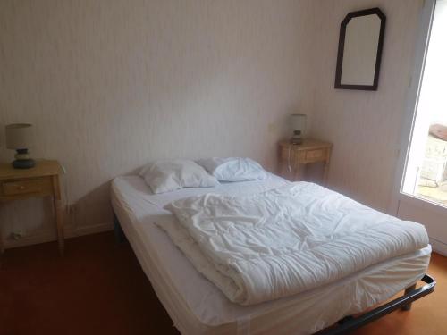 an unmade bed in a bedroom with two night stands at Maison spacieuse 9 pers, secteur calme - FR-1-476-201 in La Faute-sur-Mer