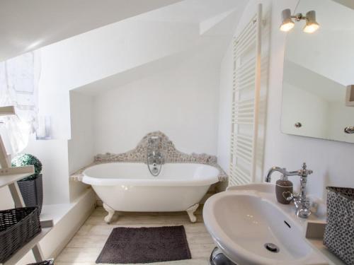 La salle de bains blanche est pourvue d'une baignoire et d'un lavabo. dans l'établissement Gîte Champagnac-de-Belair, 3 pièces, 4 personnes - FR-1-616-311, à Champagnac-de-Bélair
