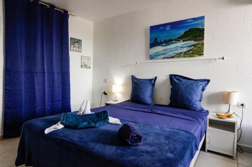 a bedroom with two beds with blue sheets at Paradis studio & plage à 1 min in Le Gosier