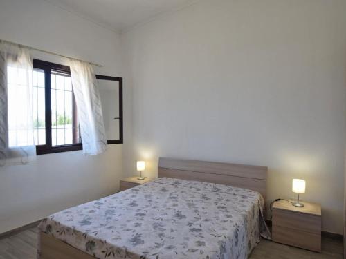 a bedroom with a bed and a window with two lamps at Holiday Home Floridia with Private Pool in Floridia