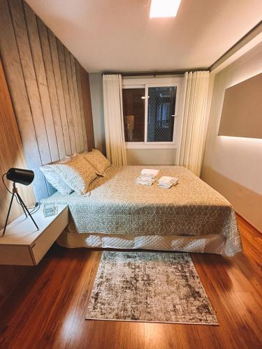 a small bedroom with a bed and a window at Apto a 3 minutos da Rua Coberta de Gramado in Gramado