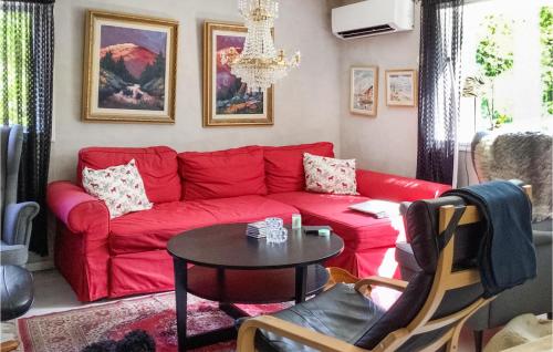 een woonkamer met een rode bank en een tafel bij Pet Friendly Home In Gvle With Wifi in Gävle