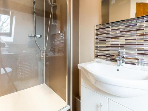 a bathroom with a sink and a shower at Ty Bach Twt in Dyffryn