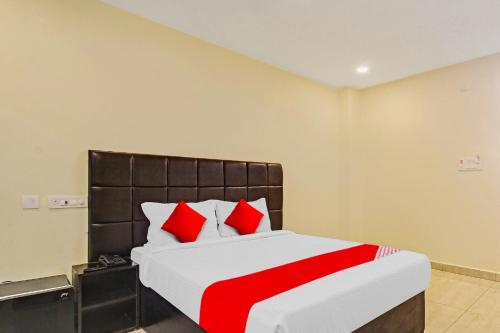 1 dormitorio con 1 cama grande con almohadas rojas en Lakshmi Royal Inn, en Warangal