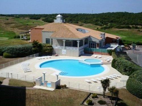 - une vue aérienne sur une maison avec une grande piscine dans l'établissement Studio face mer avec balcon et piscine chauffée, à deux pas du golf – 3 couchages - FR-1-224C-232, à Saint-Jean-de-Monts