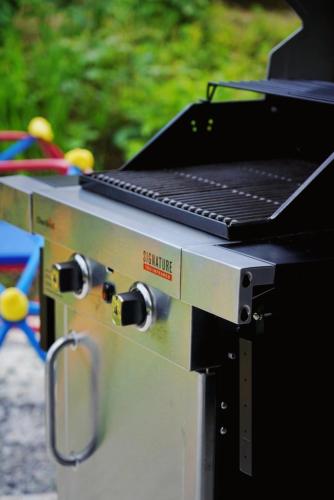 a grill with a laptop computer on top of it at 屋根付き屋外ガス式BBQ ぐらんぱる公園シャボテン動物公園絶好立地貸別荘stella 星空眺望 遊具 ホームシアター 大画面任天堂スイッチ in Ito