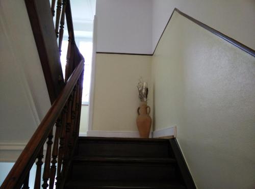 a stairway with a vase of flowers on the wall at Basel Charme Apartments in Basel