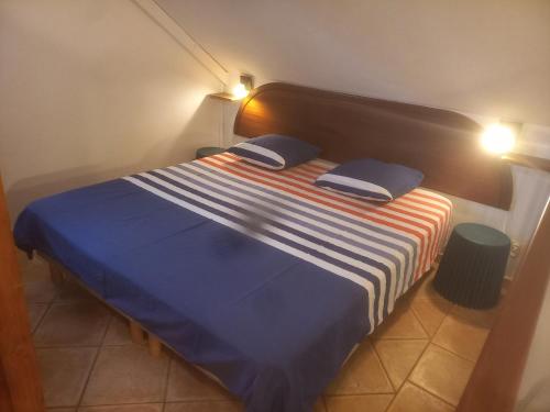 a bedroom with a bed with two pillows on it at La Perle du Sable Blanc in Saint-Gilles les Bains