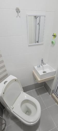 Baño blanco con aseo y lavamanos en HOTEL SHAFURA 3 en Cukai