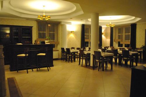 jadalnia ze stołami i krzesłami w restauracji w obiekcie Zielony Dworek w mieście Częstochowa