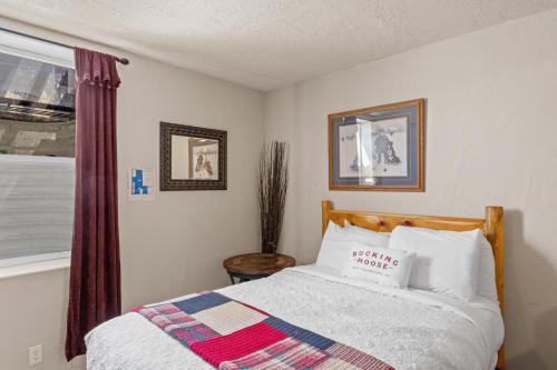 a bedroom with a bed and a window at The Bucking Moose in West Yellowstone
