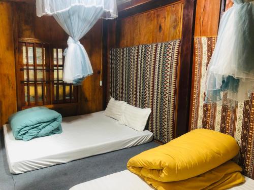 a room with two beds and a yellow pillow at Du Gia Village Homestay-Lana in Làng Cac