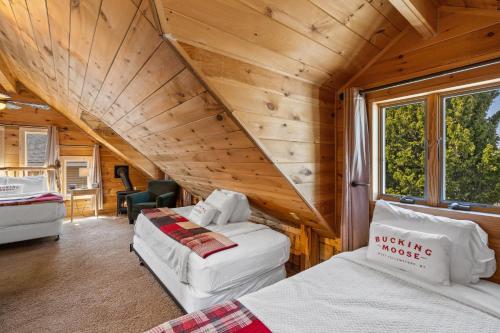 a room with two beds in a wooden cabin at The Bucking Moose in West Yellowstone
