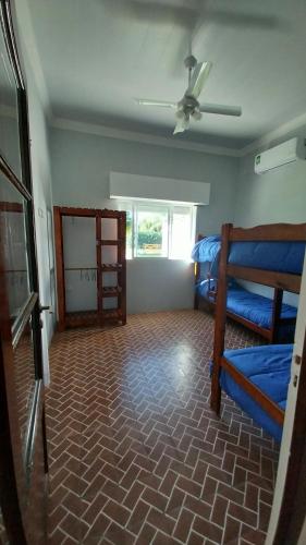 a room with two bunk beds and a ceiling fan at Casa de campo en Tomás Jofré in Tomás Jofré