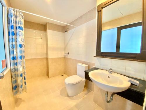 a bathroom with a sink and a toilet and a window at One World One Home Patong 2 in Patong Beach