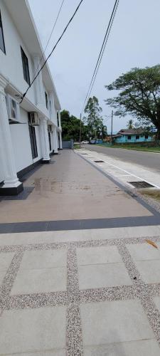 an empty street next to a white building at HOTEL SHAFURA 3 in Cukai