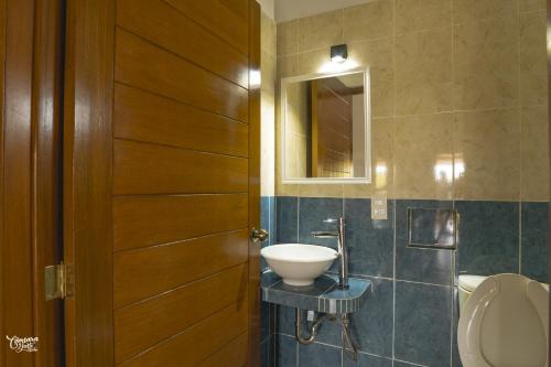 a bathroom with a sink and a mirror and a door at Hotel VidaMar in Puerto Escondido