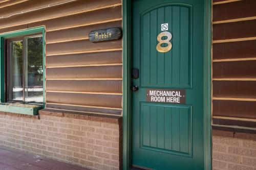 a green door on the side of a house at The Bucking Moose in West Yellowstone