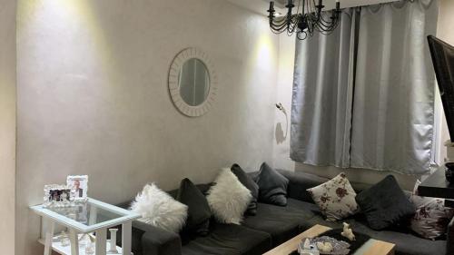 een woonkamer met een bank en een spiegel bij Dechira aljadida agadir in Dcheïra