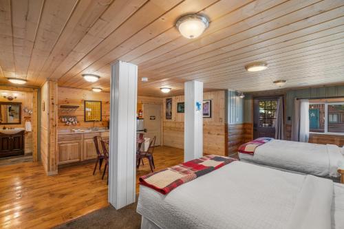 a bedroom with two beds and a kitchen in a cabin at The Bucking Moose in West Yellowstone