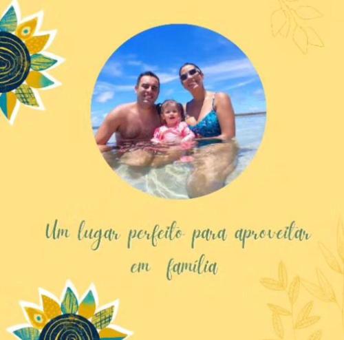 a picture of a couple and a baby in the water at Pousada Dona Felicidade Carneiros in Tamandaré