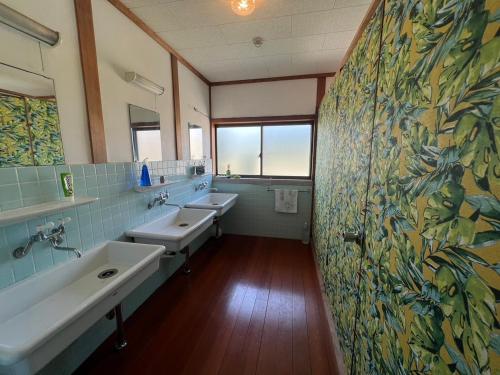 a bathroom with two sinks and two mirrors at Cozy and Cheap Kinosaki Hideya Non Japanese in Toyooka