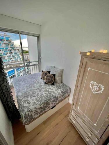 une chambre avec un lit avec des oreillers et une fenêtre dans l'établissement Ô Septième Ciel, à La Grande Motte