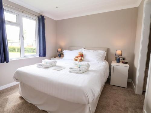 a bedroom with a large white bed with towels on it at Callow Lodge 15 in Hadnall