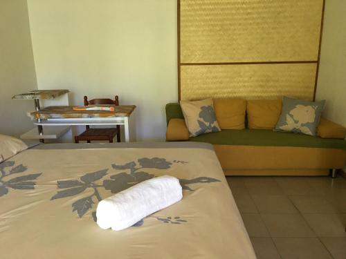 ein Hotelzimmer mit einem Bett und einem Sofa in der Unterkunft Pension Te Aroha - Te Arii in Maatea