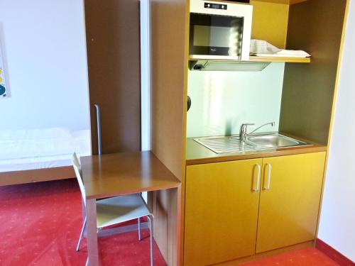 a small kitchen with a table and a sink at Orange Wings Krems in Krems an der Donau