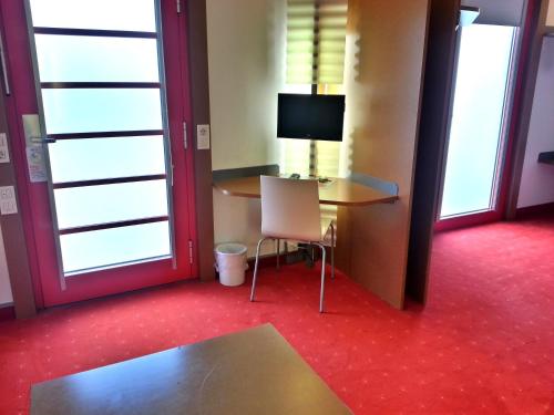 a room with a desk with a computer and a chair at Orange Wings Krems in Krems an der Donau