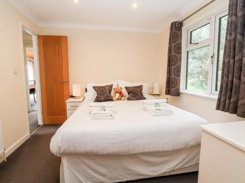 a bedroom with a white bed with two towels on it at Callow Lodge 5 in Hadnall