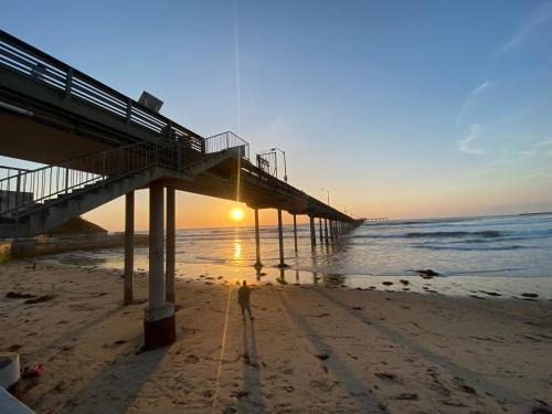 a person standing on the beach under a pier at 5079 Lotus Street in San Diego