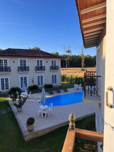 a villa with a swimming pool and a house at Pousada Portal de Paraty in Paraty