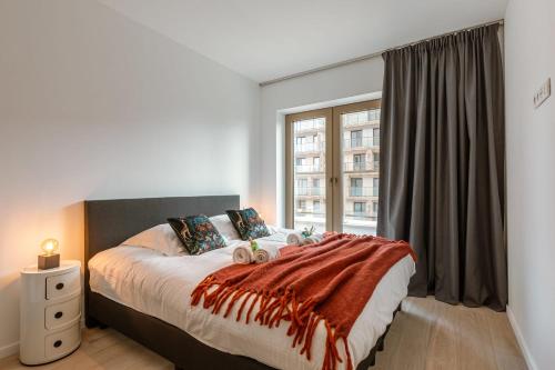 um quarto com uma cama grande e uma janela em Beautifully decorated apartment with sunny terrace em Oostende