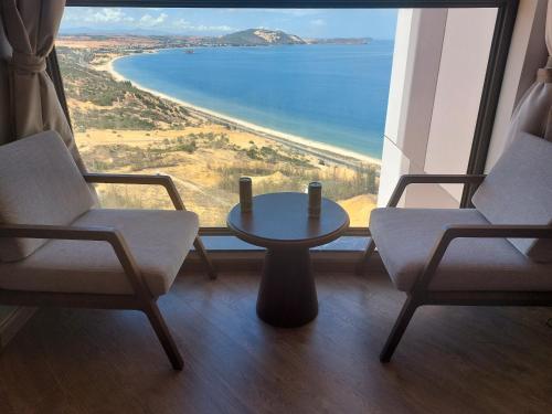 a room with two chairs and a table in front of a window at APEC Mandala Cham Bay Mũi Né in Ấp Thiẹn Ái