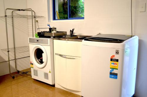 a kitchen with a washing machine and a sink at City Escape Taroona in Taroona