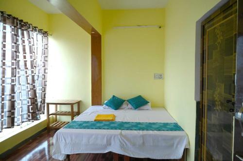 Un dormitorio con una cama con almohadas azules y una ventana en OYO Hotel River en Bhilai