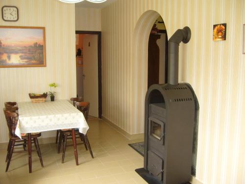 a living room with a wood stove in a room with a table at Ország Apartmanház in Zalakaros