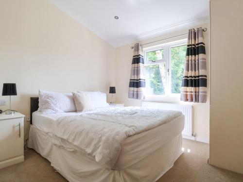 a white bedroom with a large bed and a window at Callow Lodge 22 in Hadnall