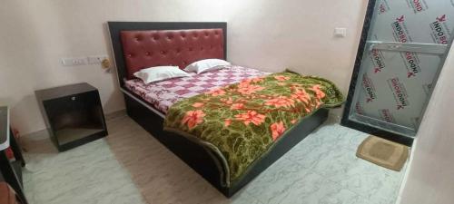 ein kleines Schlafzimmer mit einem Bett mit rotem Kopfteil in der Unterkunft OYO 81285 Hotel Chanda in Madhubani