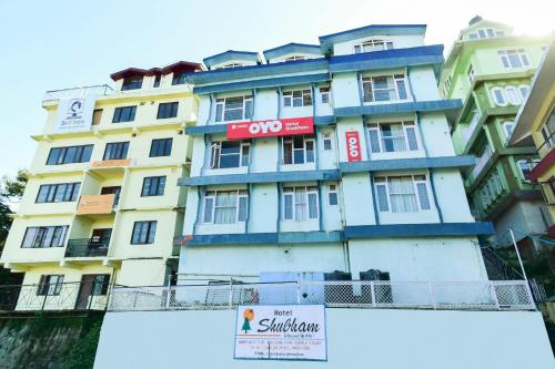 a tall building with a sign in front of it at Hotel Shubham in Shimla