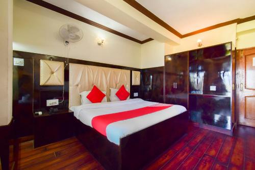 a bedroom with a large bed with red pillows at Hotel Shubham in Shimla