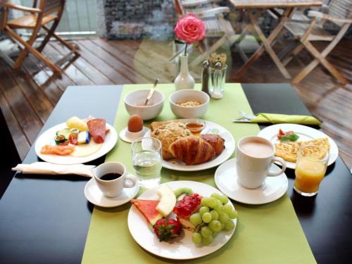 فندق آر آند جيه في روست: طاولة مع أطباق من الطعام وأكواب من القهوة