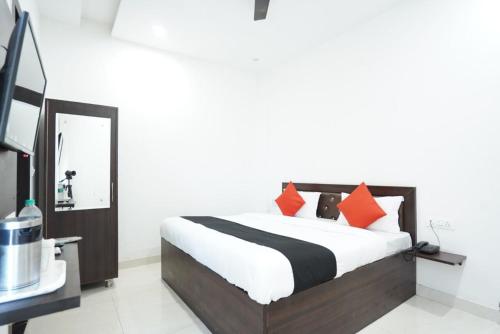 Karnal的住宿－Hotel Star Inn，一间卧室配有带橙色和黑色枕头的床